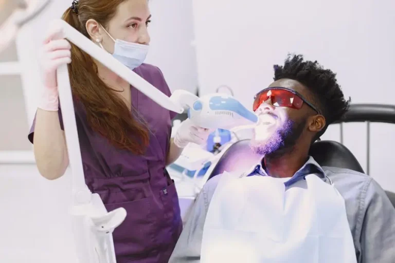 Dentist performing an in-office teeth whitening procedure