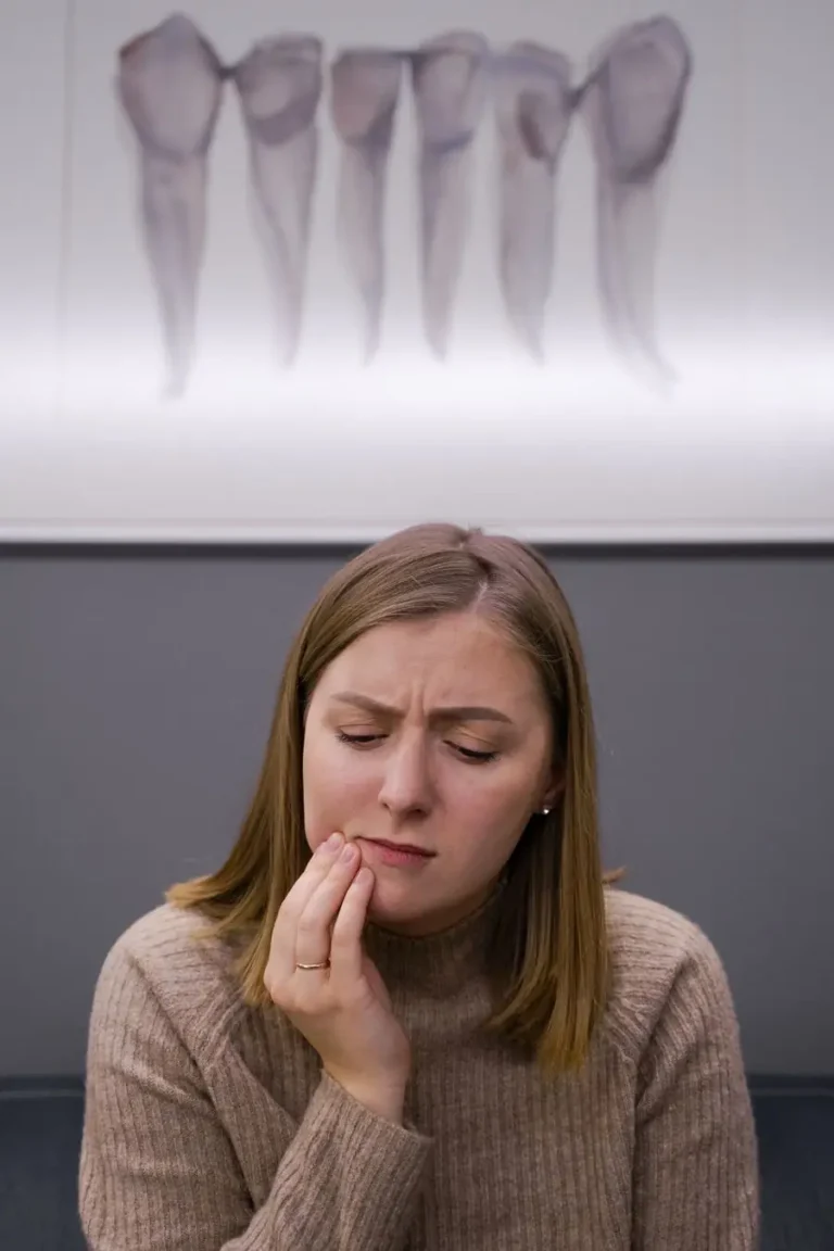 Woman holding her cheek because of tooth pain