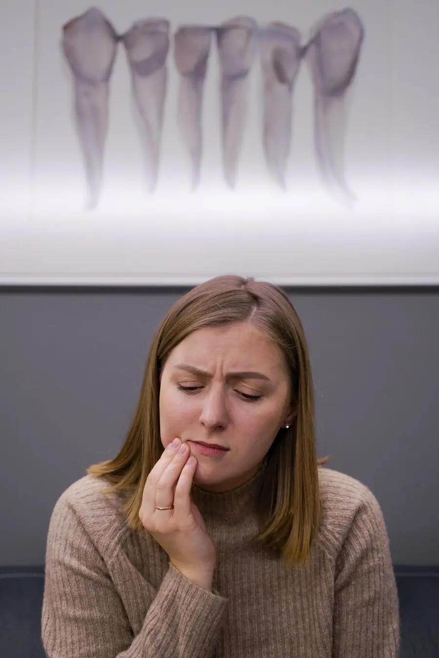 Woman holding her cheek because of tooth pain