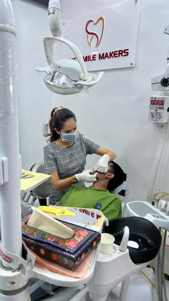 Dentist examining a patient in the chair at The Smile Makers Dental Clinic