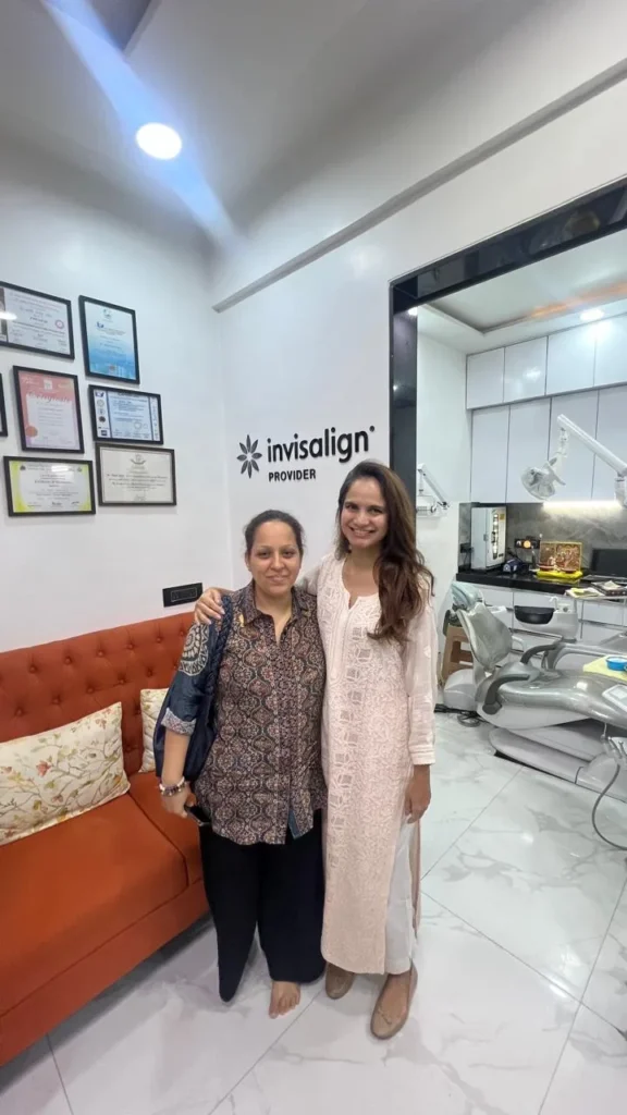 Two women in front of the Invisalign Provider sign at The Smile Makers Dental Clinic